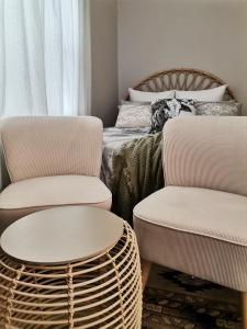 dwa krzesła i stół w pokoju z łóżkiem w obiekcie Izibusiso Guest room w mieście East London
