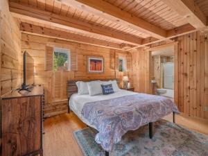 een slaapkamer met een bed in een houten hut bij Luxury Cabin 45 Min to Asheville Hot Tub & Fire pit in Marion