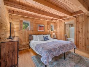 une chambre avec un lit dans une cabane en bois dans l'établissement Luxury Cabin 45 Min to Asheville Hot Tub & Fire pit, à Marion