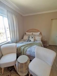 a bedroom with a bed and two chairs at Izibusiso Guest room in East London