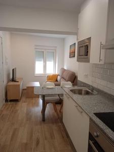 a kitchen and living room with a couch and a table at La casa del Timón.Planta baja in Muros