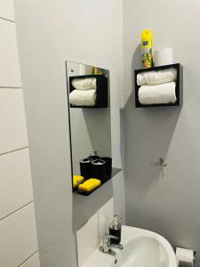 a bathroom with a sink and a mirror and towels at Cozy Life-style Apartment in Maboneg in Johannesburg