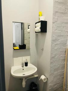 a white bathroom with a sink and a mirror at Cozy Life-style Apartment in Maboneg in Johannesburg