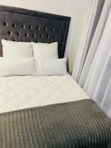 a bed with a black headboard and white sheets and pillows at Cozy Life-style Apartment in Maboneg in Johannesburg