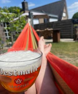 una persona sosteniendo un vaso de cerveza y una cometa en Relax, en Kasterlee