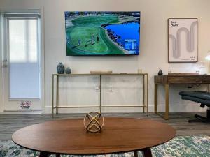 a living room with a table and a tv on the wall at Bright Top Floor-Elevator-Walk Downtown-Laundry in Walnut Creek