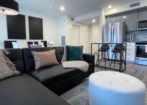 uma sala de estar com um sofá preto e uma cozinha em Elevator-Downtown View-Garage-King Bed-Laundry em Walnut Creek