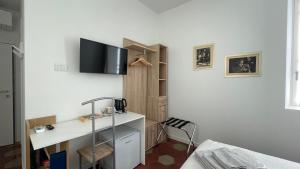 um quarto com uma secretária e uma televisão na parede em Santa Vincenza - Suite Indipendente em Lovere