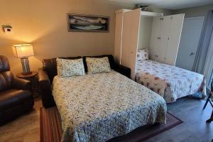 a bedroom with two beds and a couch and a lamp at Condo Daytona Beach in Daytona Beach Shores