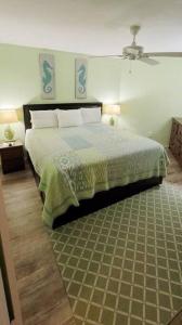a bedroom with a bed with a green comforter at Condo Daytona Beach in Daytona Beach Shores