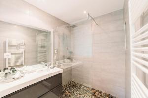 a bathroom with two sinks and a shower at Hôtel Font Mourier in Cogolin