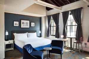 Hastings的住宿－The Confluence Hotel，酒店客房带一张床、椅子和窗户