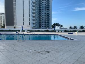 uma piscina em frente a alguns edifícios altos em Pavilion em Miami Beach