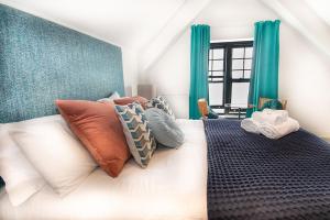 a bedroom with a large bed with pillows on it at Beachcliff Rooms & Apartments in Cardiff