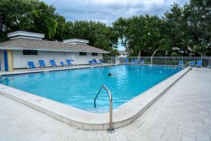 a large swimming pool with blue chairs in it at Sea Woods 115 in New Smyrna Beach