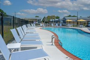 a row of lounge chairs next to a swimming pool at Shore Point Cottages in Ocean City