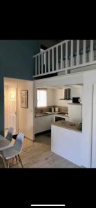 a kitchen with white cabinets and a table and chairs at Appartement de standing avec terrasse in Saintes-Maries-de-la-Mer