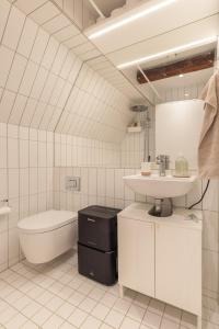 a white bathroom with a sink and a toilet at Charming Loft City Center in Copenhagen