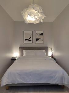 een slaapkamer met een wit bed en een kroonluchter bij Super asukohas modernne korter! in Pärnu