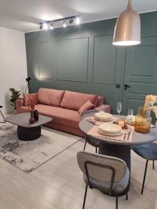 een woonkamer met een roze bank en een tafel bij Super asukohas modernne korter! in Pärnu