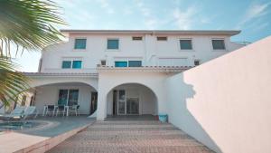 - un bâtiment blanc avec une terrasse et un palmier dans l'établissement Spectacular Villa with Private Pool in Antalya, à Belek
