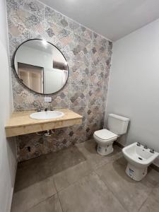 a bathroom with a sink and a toilet and a mirror at Mono ambiente de lujo en San Miguel de tucuman in San Miguel de Tucumán