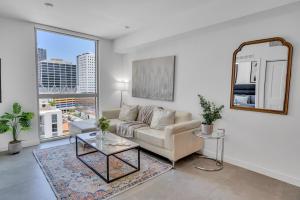 uma sala de estar com um sofá e um espelho em Amazing Unit in Downtown Miami With Free Parking em Miami