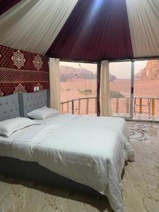 a bedroom with a bed with a view of a desert at Joy to Wadi Rum in Wadi Rum