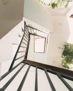 a staircase in a house with white walls and a window at Mero Hotel Boutique in Barra Grande