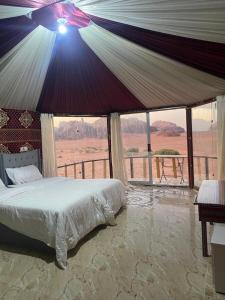 a bedroom with a bed and a view of the desert at Joy to Wadi Rum in Wadi Rum