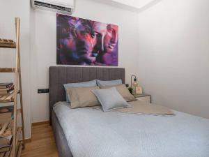 1 dormitorio con 1 cama con una pintura en la pared en Daedalus en Athens