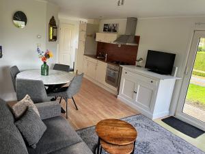 a living room with a couch and a table at Rustig chalet 4 personen op recreatiepark de Friese Wadden Tzummarum buitenzwembad aanwezig op het park in Tzummarum