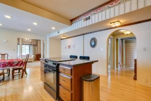 Il comprend une cuisine équipée d'une cuisinière et une salle à manger avec une table. dans l'établissement Historic Auburn Home with Theater and Yard!, à Auburn