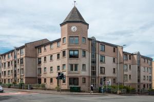 a building with a clock tower on top of it at Ground Floor 2 Bed Flat Slateford in Edinburgh