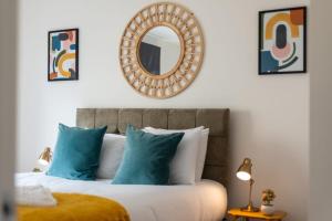 um quarto com uma cama com almofadas azuis e um espelho em Ground Floor 2 Bed Flat Slateford em Edinburgo