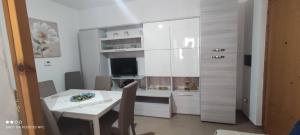 a white kitchen with a table and a dining room at Da Serraona appartamento ad Alghero in Alghero
