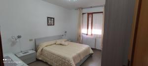 a small bedroom with a bed and a window at Da Serraona appartamento ad Alghero in Alghero