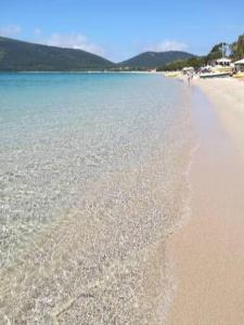 a beach with water and a person walking on it at Da Serraona appartamento ad Alghero in Alghero