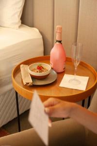 a table with a bowl of food and a bottle of wine at Mero Hotel Boutique in Barra Grande