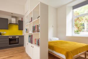 een slaapkamer met een bed en een boekenplank bij Artist's Studio in Stockbridge in Edinburgh
