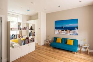 a living room with a blue couch and a book shelf at Artist's Studio in Stockbridge in Edinburgh