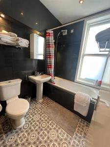 a bathroom with a toilet and a tub and a sink at The Townhouse in Waterloo sleeps 4 in Waterloo