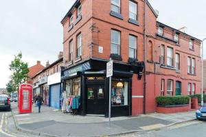 una calle con una cabina de teléfono rojo frente a un edificio en The Townhouse in Waterloo sleeps 4, en Waterloo