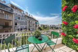 un balcone con tavolo, sedie e fiori di Irodis at Koukaki By Greece Apartment ad Atene