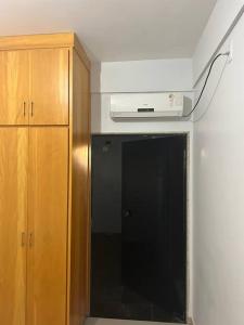 a room with a kitchen with a microwave and a cabinet at Apartamento completo ao lado praça dos girassóis in Palmas