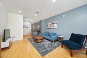 a living room with a blue couch and a tv at City-View Chicago 3-BR Rooftop in Chicago