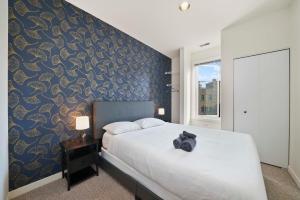 a bedroom with a bed with a blue and gold wall at City-View Chicago 3-BR Rooftop in Chicago