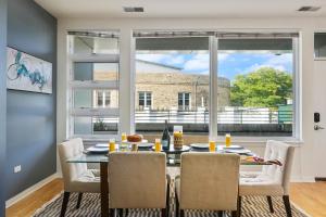 a dining room with a table and chairs and a large window at City-View Chicago 3-BR Rooftop in Chicago