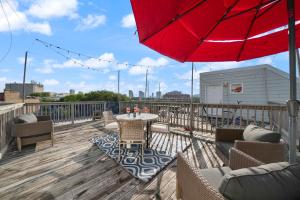 a patio with a table and chairs and a red umbrella at City-View Chicago 3-BR Rooftop in Chicago