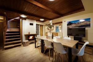 a dining room with a table and a fireplace at Chalet Green Park in Stará Lesná